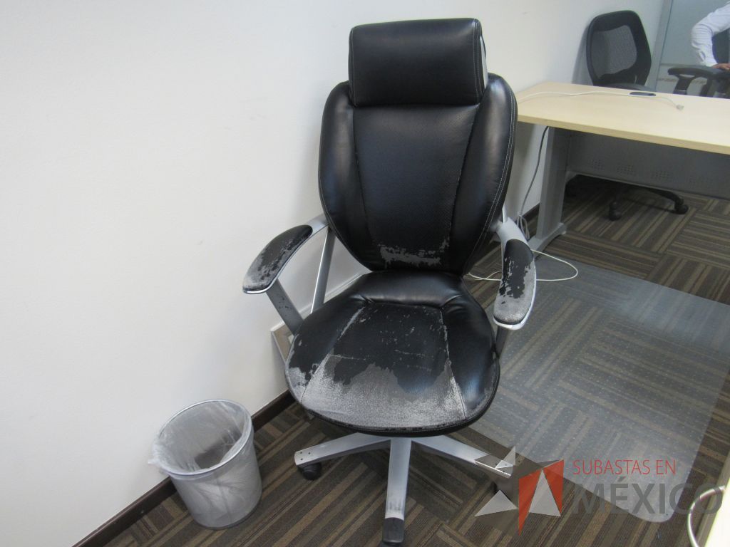Lote 050 - Silla en acabado tipo piel, con ruedas, descansa brazos y cabecera