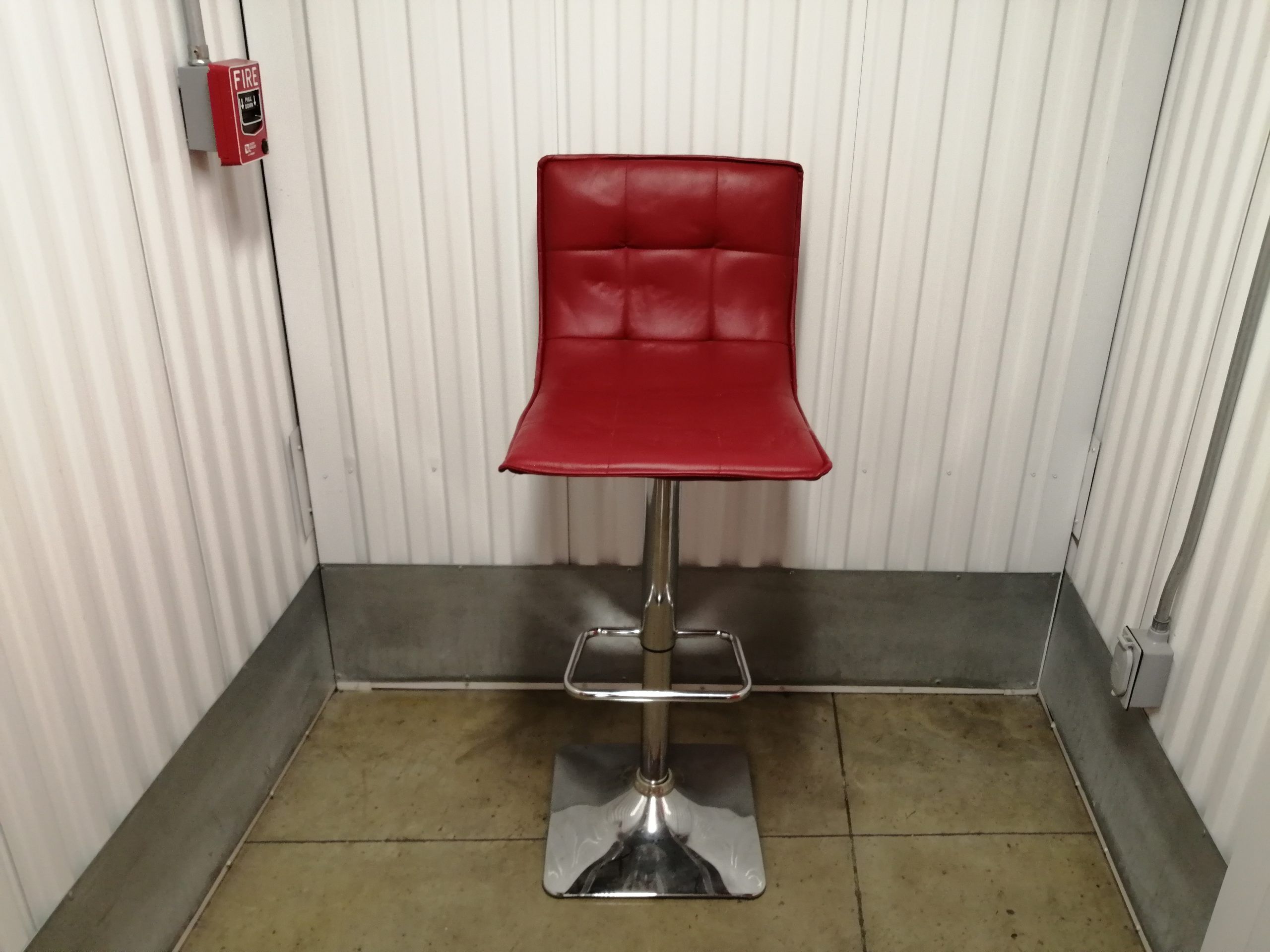 Lote 072 - Banco alto con base de metal con asiento y respaldo tipo piel color rojo.