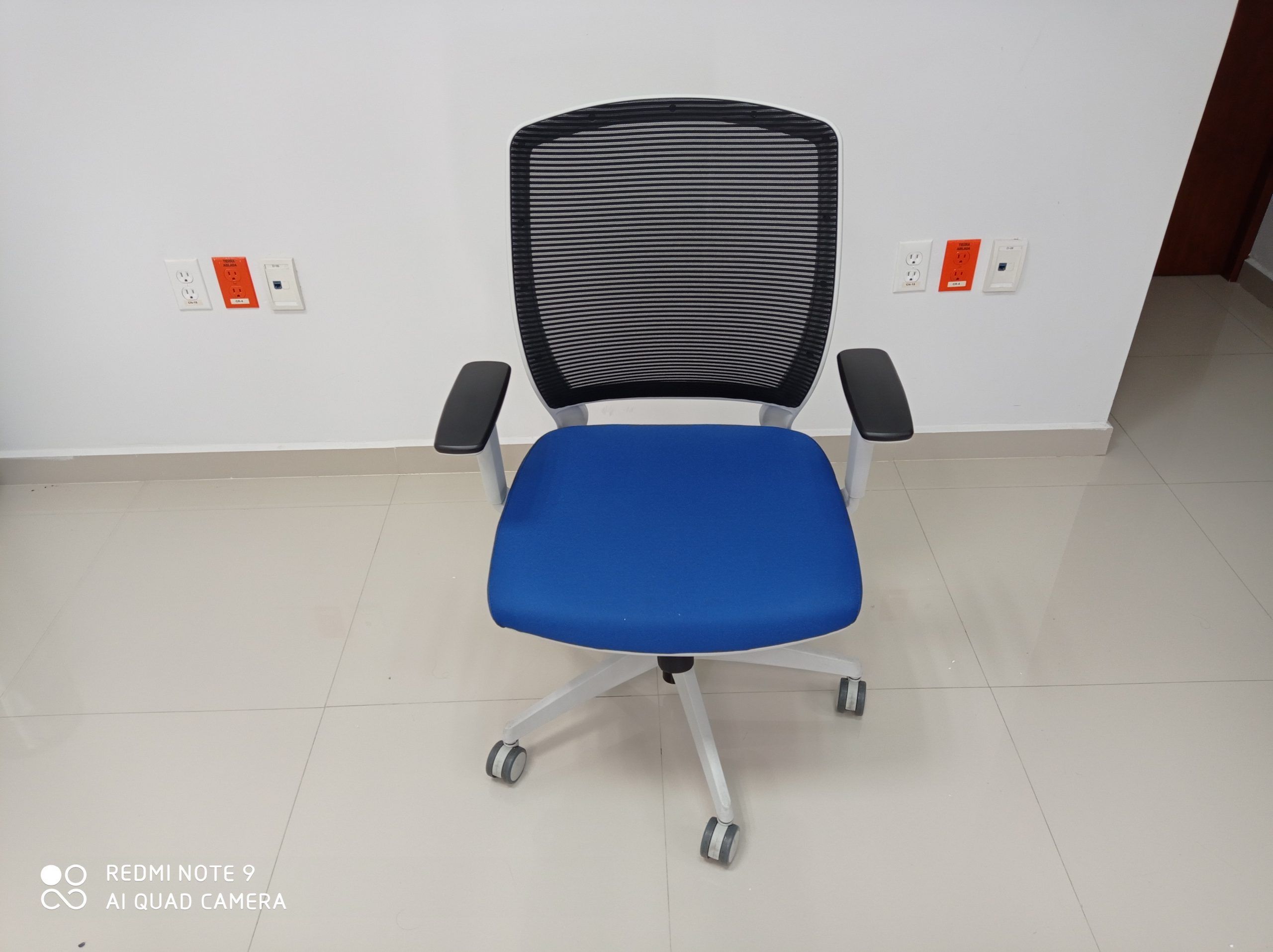 Lote 008 - 4 Sillas ejecutivas con ruedas,descansabrazos fijos,asiento en tela color azul,respaldo en malla negra. - Imagen 4