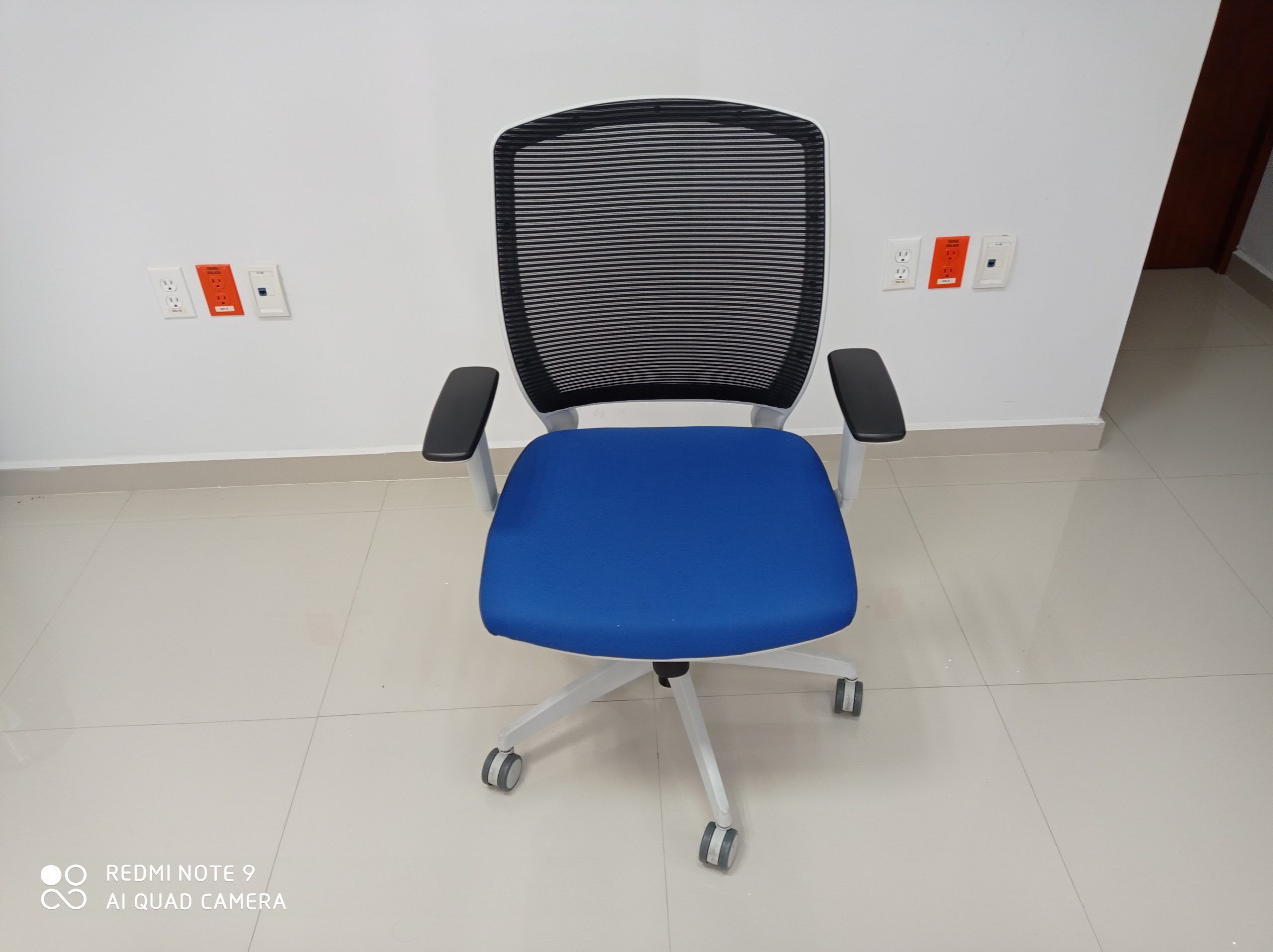 Lote 008 - 4 Sillas ejecutivas con ruedas,descansabrazos fijos,asiento en tela color azul,respaldo en malla negra.