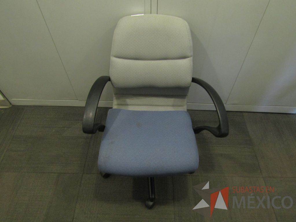 Lote 123 - Silla operativa con ruedas, descansabrazos fijo, asiento y respaldo en tela color azul con gris. ( En mal estado.)