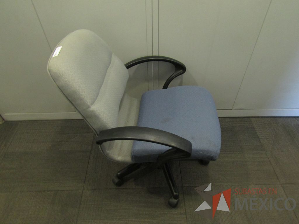 Lote 123 - Silla operativa con ruedas, descansabrazos fijo, asiento y respaldo en tela color azul con gris. ( En mal estado.) - Imagen 4