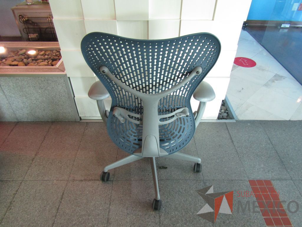 Lote 060 - Silla operativa con ruedas, descansabrazos fijo, asiento en malla color gris y respaldo en plástico color azul - Imagen 6