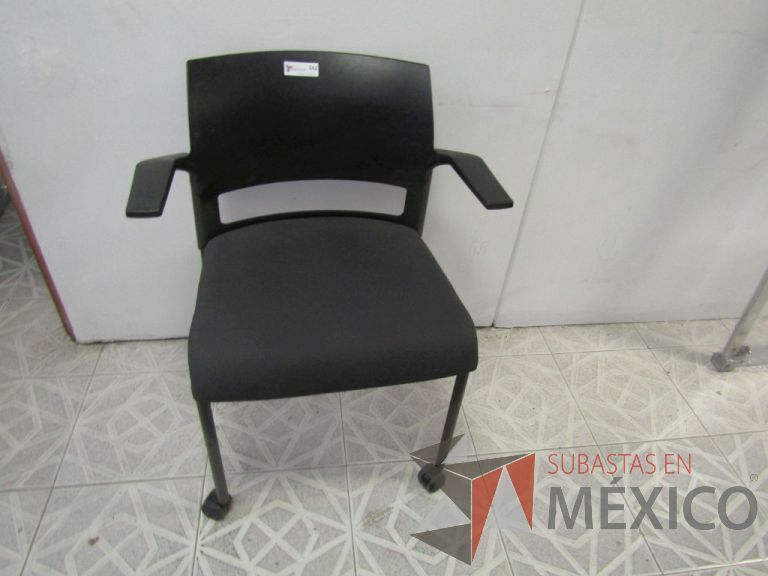 Lote 021 - Silla de visita con descansabrazos, patas metálicas con ruedas, asiento en tela color negro y respaldo de plástico color negro