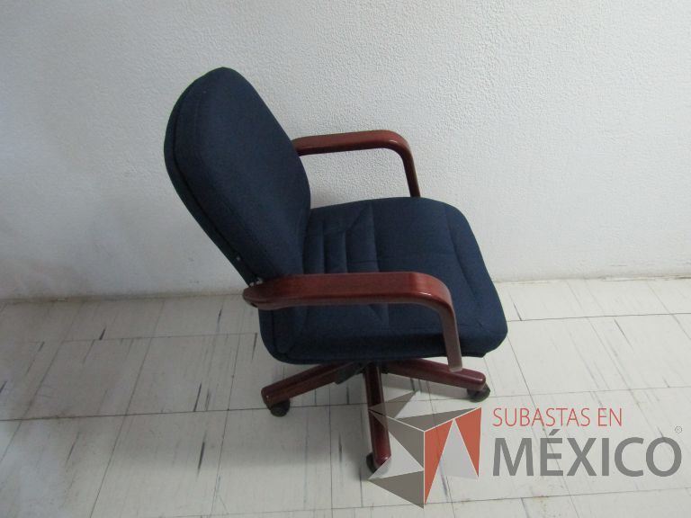 Lote 133 - Silla ejecutiva con ruedas, descansabrazos de madera, asiento y respaldo en tela color azul - Imagen 4