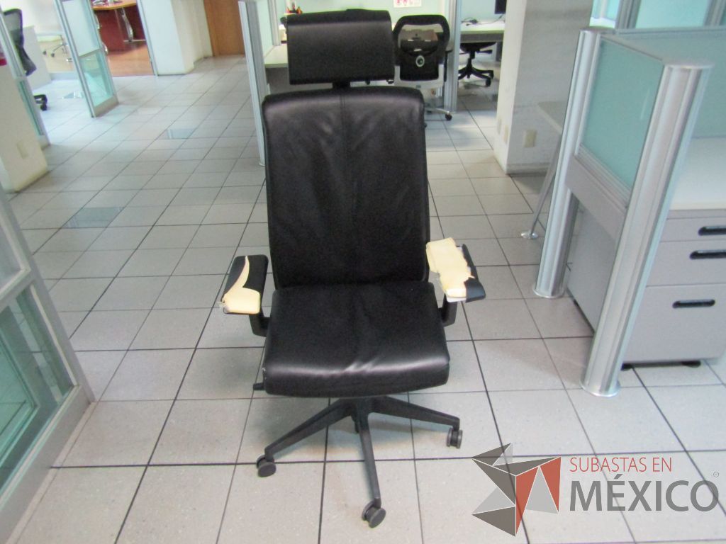 Lote 318 - Silla operativa con ruedas, descansabrazos, cabecera, asiento y respaldo en piel color negro