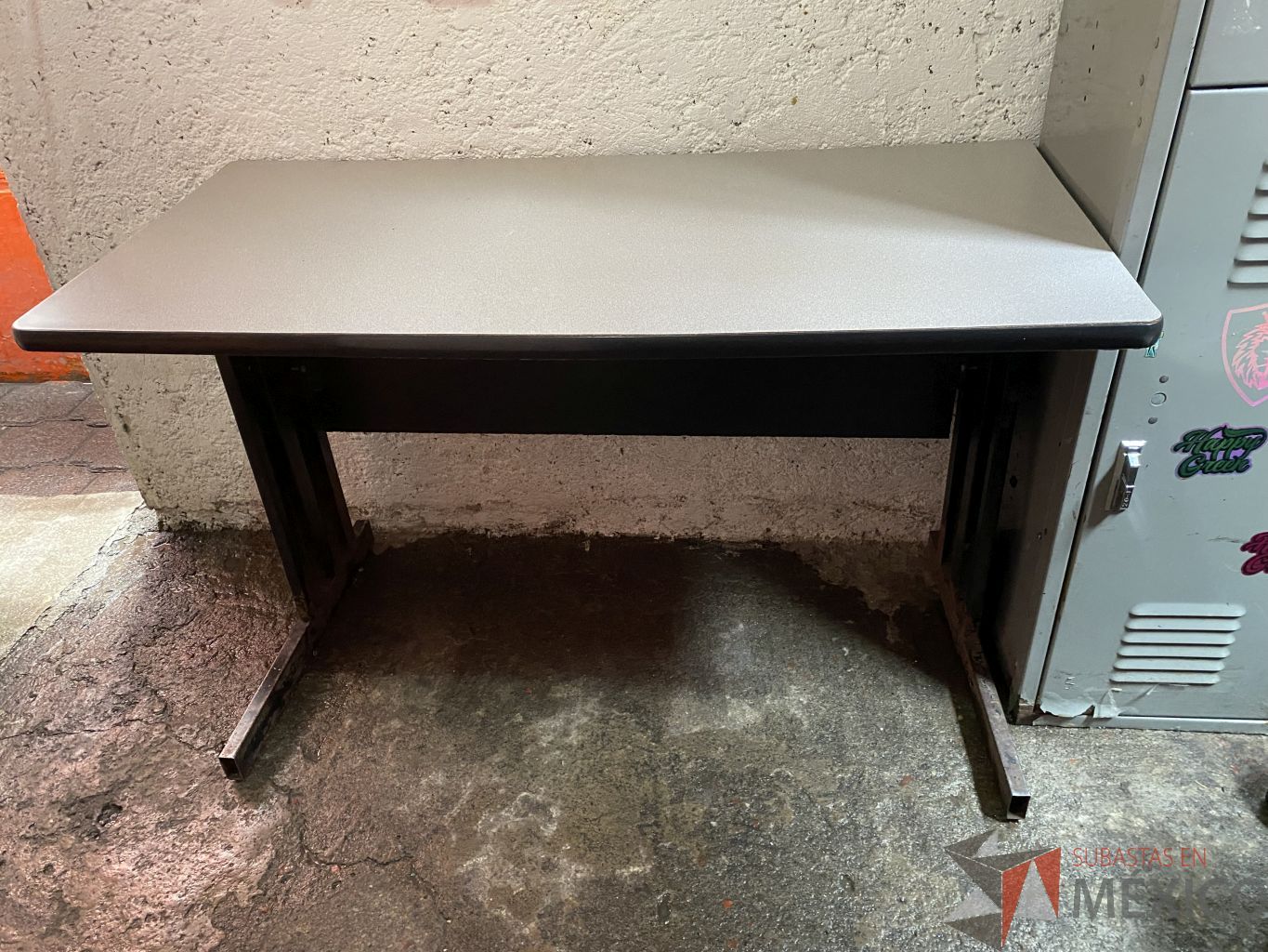 Lote 064 - Mesa de trabajo con base metalica y cubierta en color gris